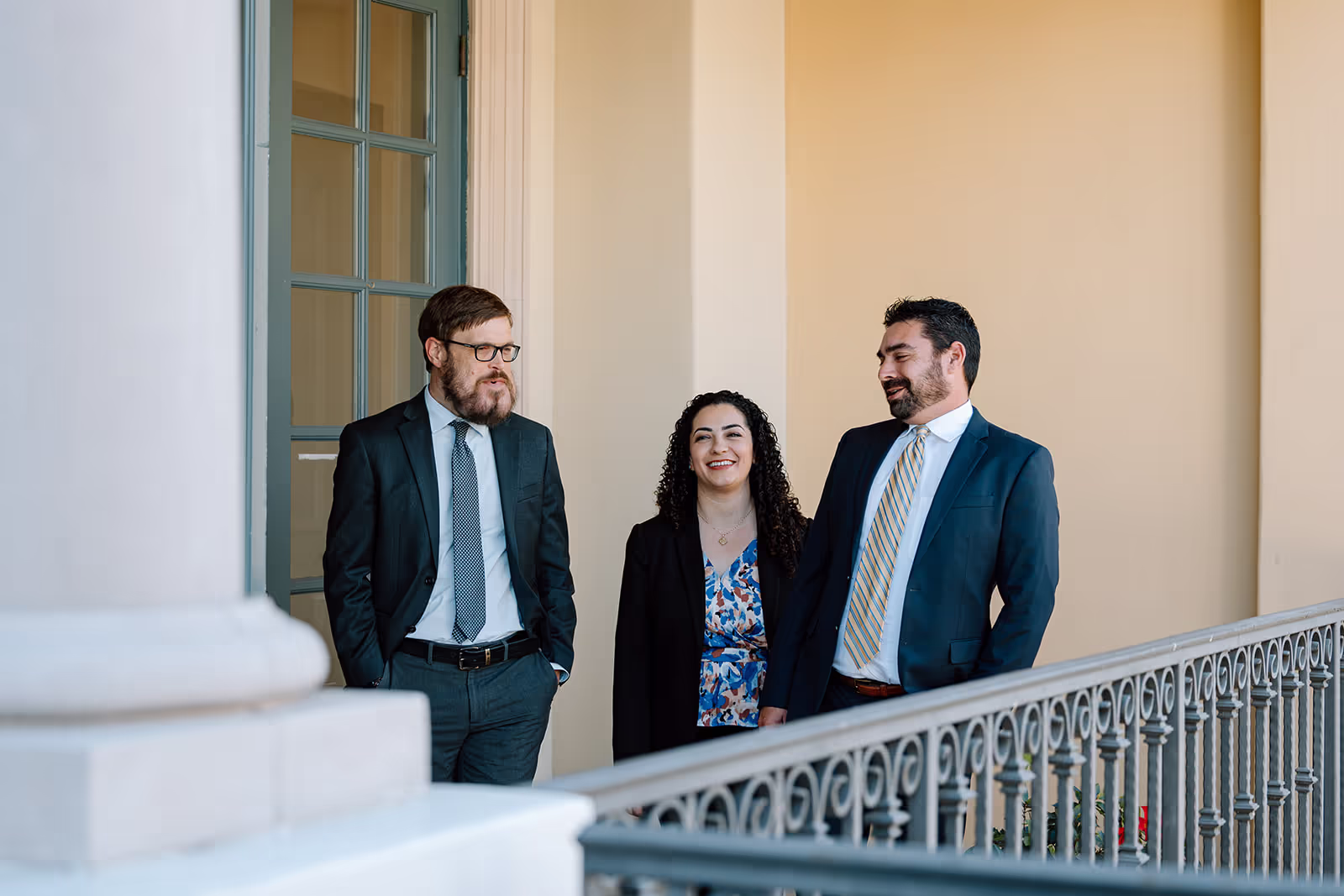 Lawyers walking along a balcony speaking to one another.