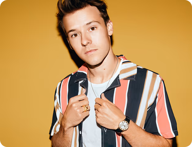 Headshot of a cool young man with a colorful striped shirt and watch.