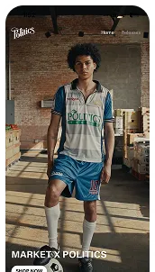 Young man standing in a warehouse wearing a Politics brand sports outfit with blue shorts and white jersey.
