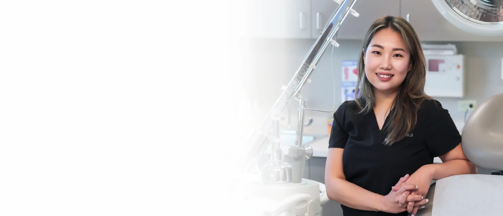 Dr. Dami, board-certified plastic surgeon in Denver, standing confidently in a modern medical setting. 