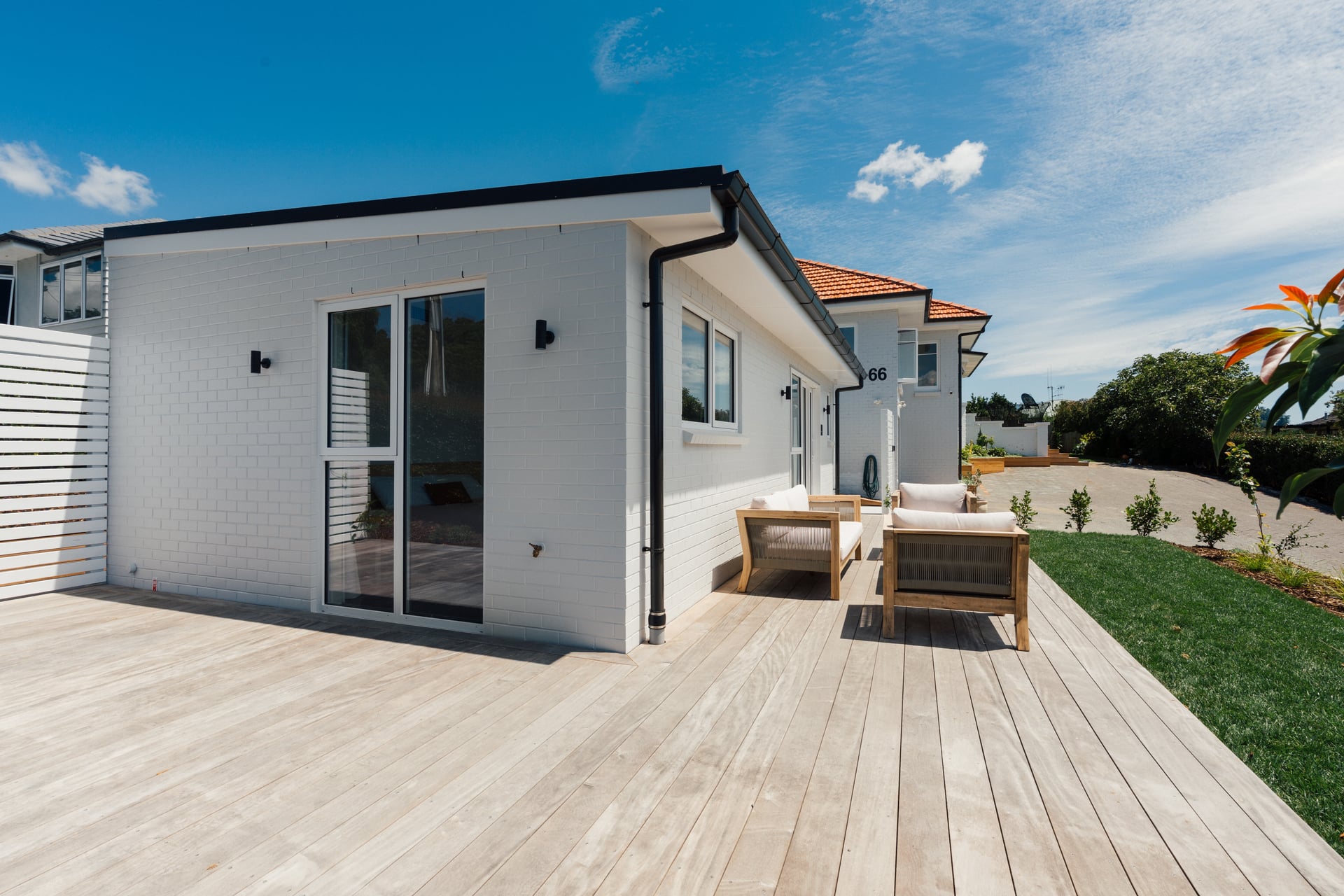 White-clad Judea minor dwelling with timber deck and outdoor seating area built by Gardo Group in Tauranga