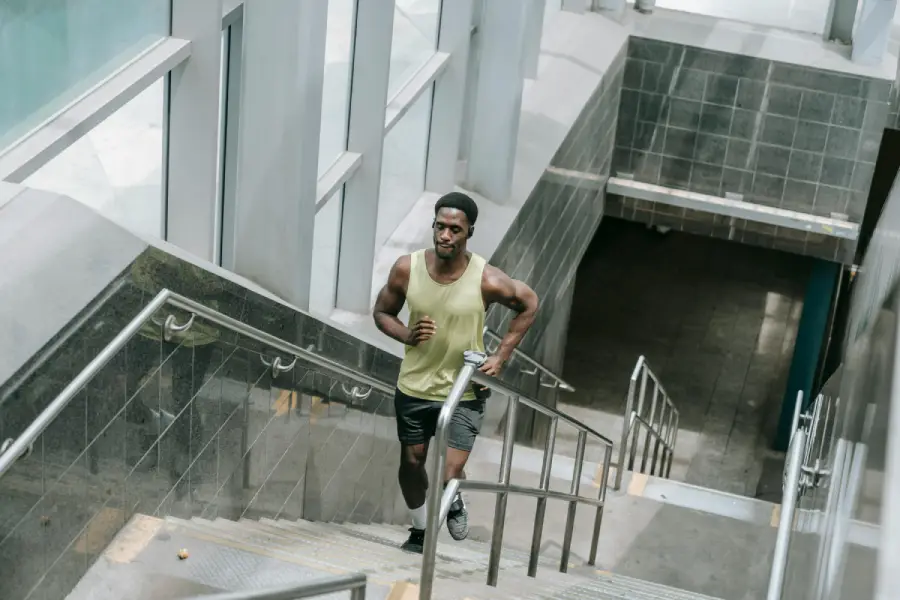 Athlete running up indoor stairs for conditioning and endurance training, focusing on speed, power, and cardiovascular fitness.