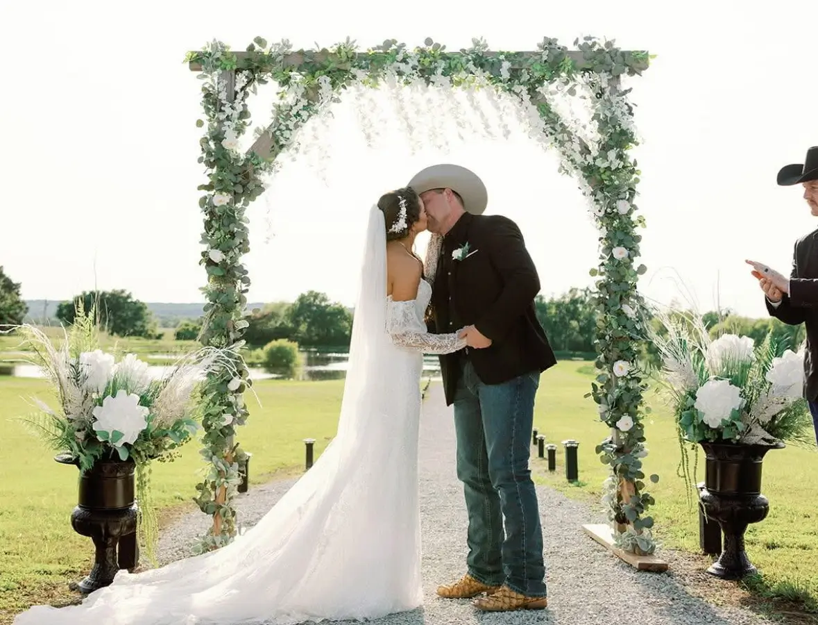 A photo captured by a wedding guest during the ceremony of the couple kissing