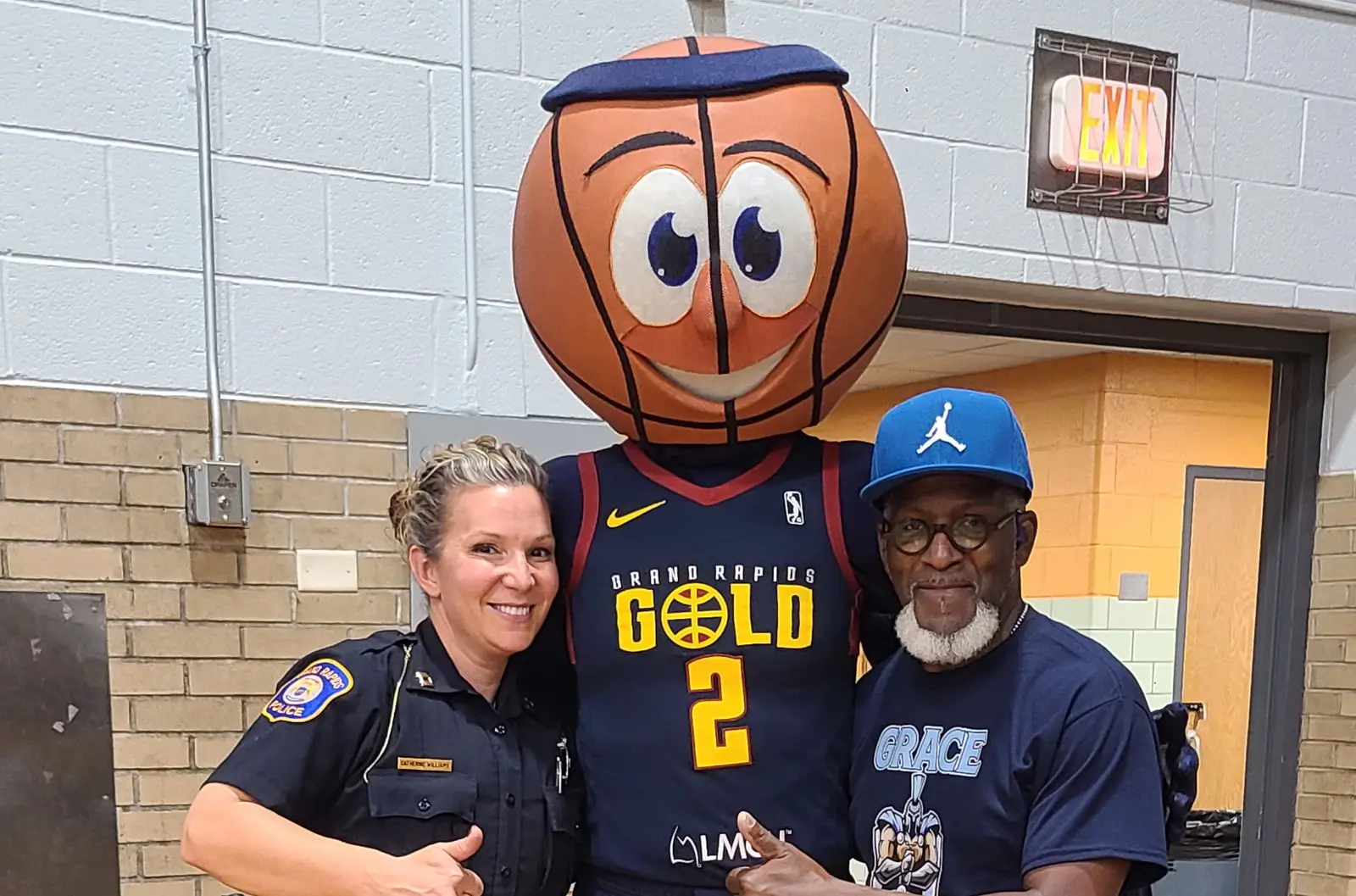 Three people posing for a photo captured by a guest at a sports event