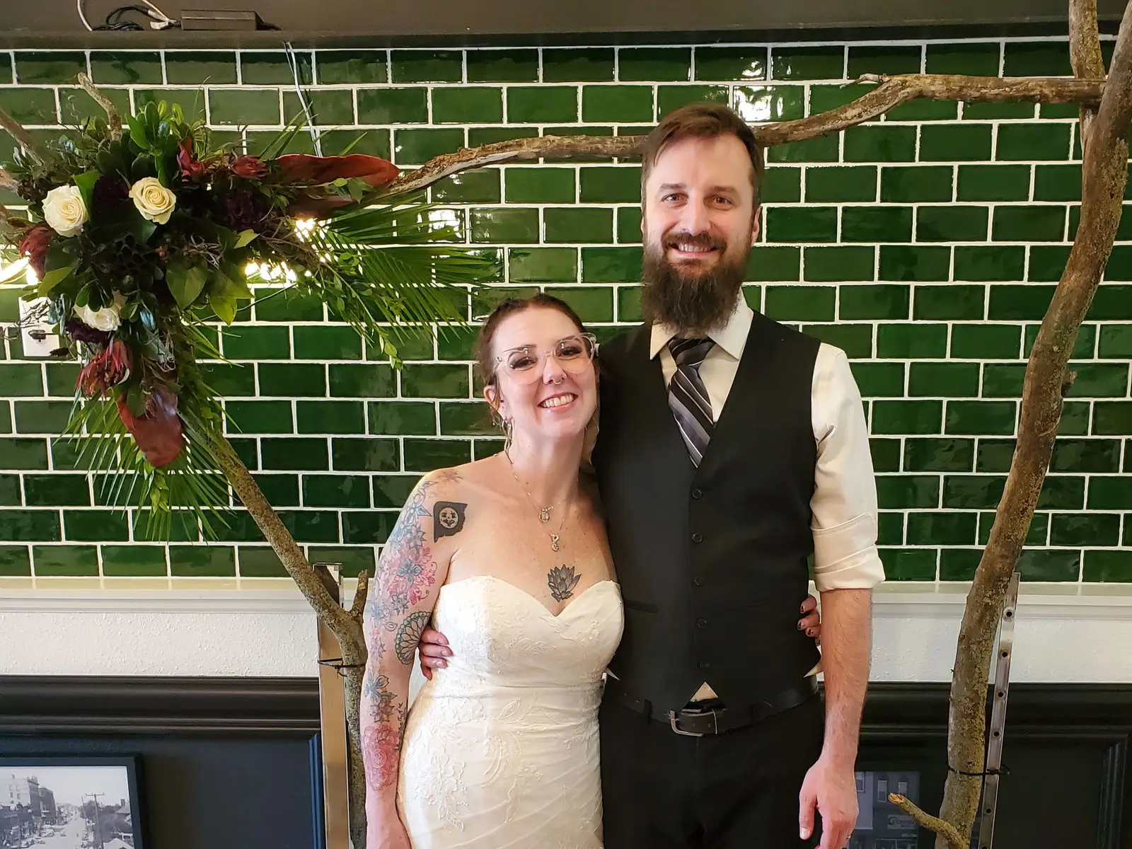 A wedding couple posing for a photo behind their photo booth