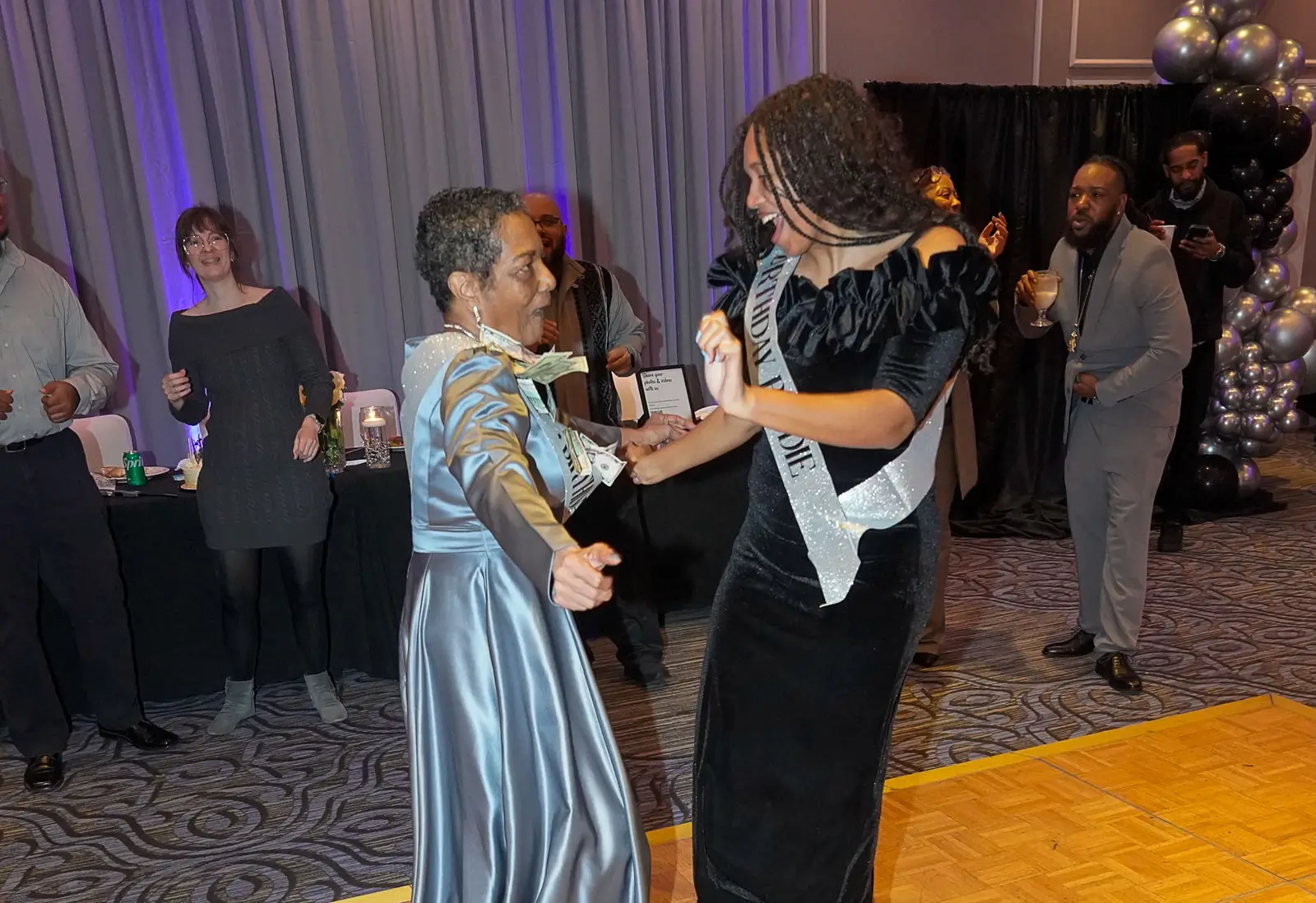 Birthday celebrant dancing with daughter at her 70th birthday party