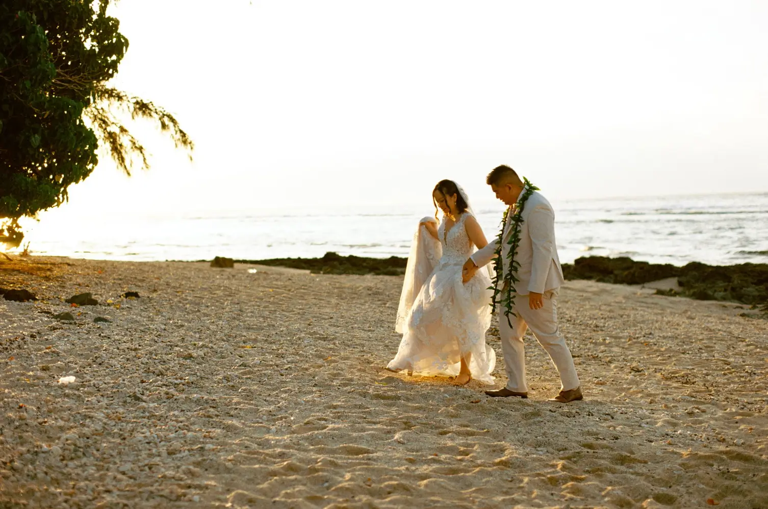 Wedding couple holding hands at the beach