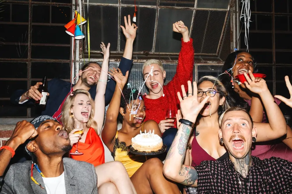 Group of friends celebrating with cake and drinks
