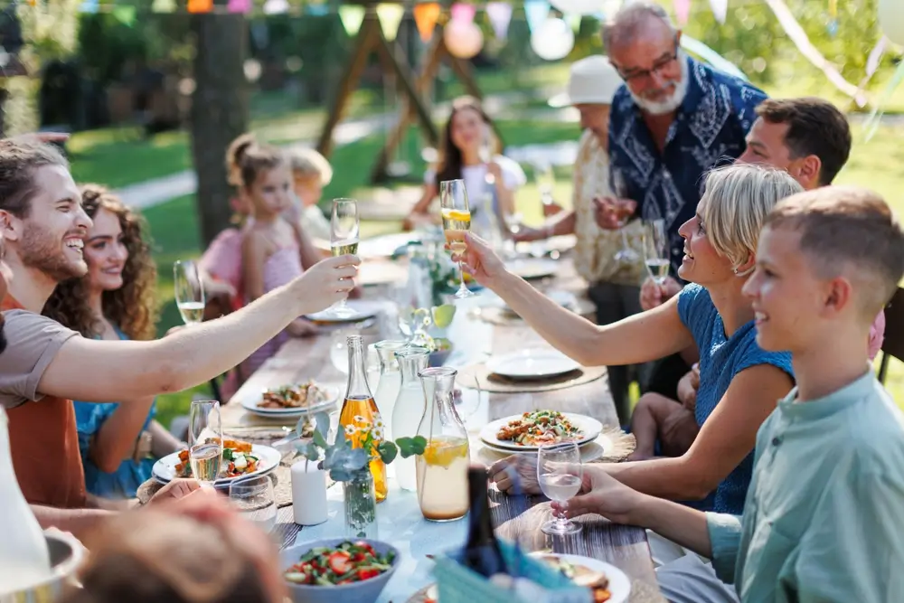 Family clinking glasses at summer garden party