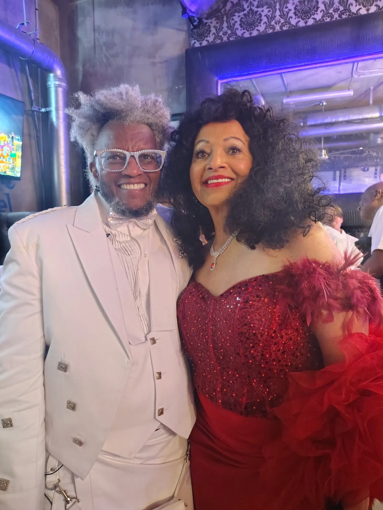 Two people posing at a birthday party reception