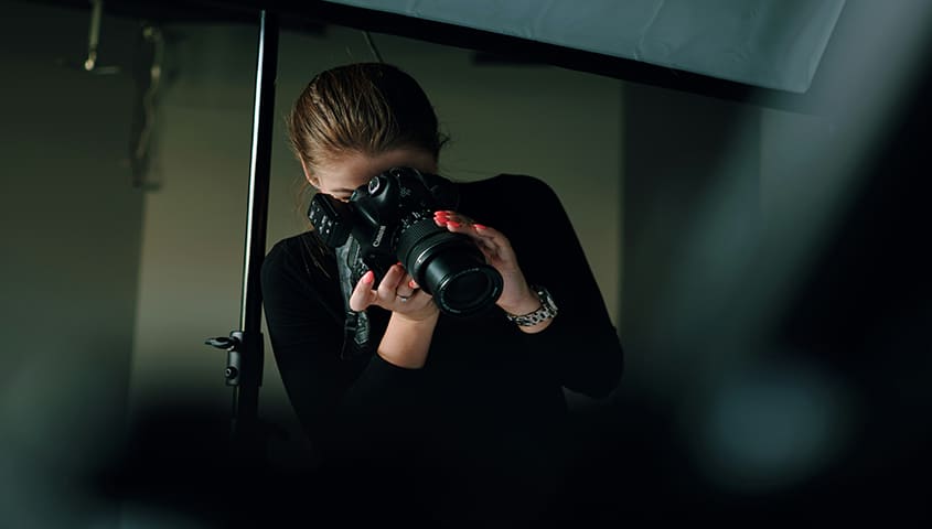 woman taking photos with a camera, a creative example of business ideas for women