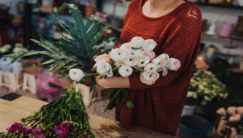 woman arranging fresh flowers in a shop as a business idea for women