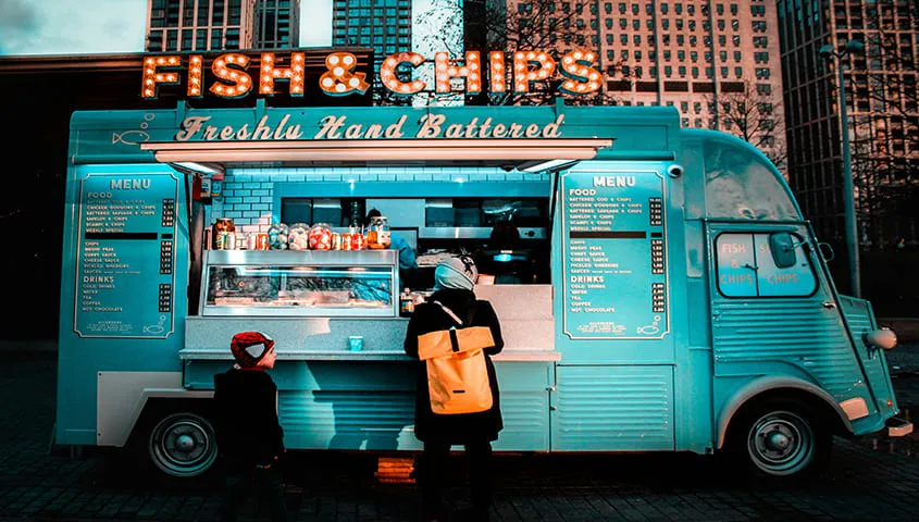 female chef cooking and serving from a mobile food truck as a creative business idea
