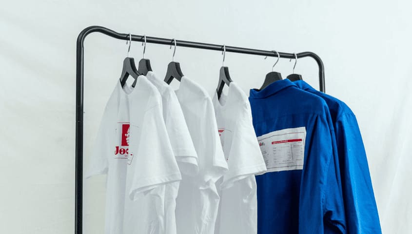 Several custom DTG printed T-shirts are hanging on the clothes hanger.