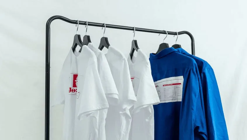 Several custom DTG printed T-shirts are hanging on the clothes hanger.