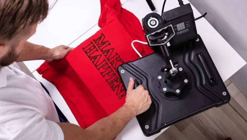 A man printing text on a custom T-shirt