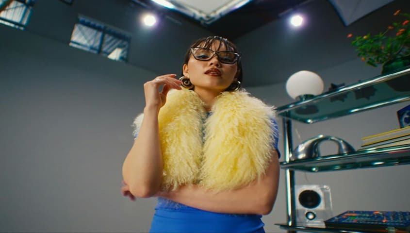 A woman is dressed in extremely maximalist gen z clothing.