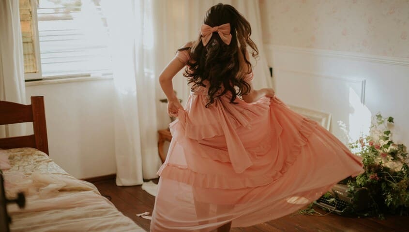 Girl twirling in a 1980s-inspired pink ruffled dress