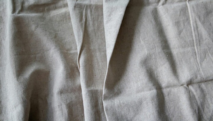 Linen fabric texture showing a natural, breathable type of fabric used in clothing.