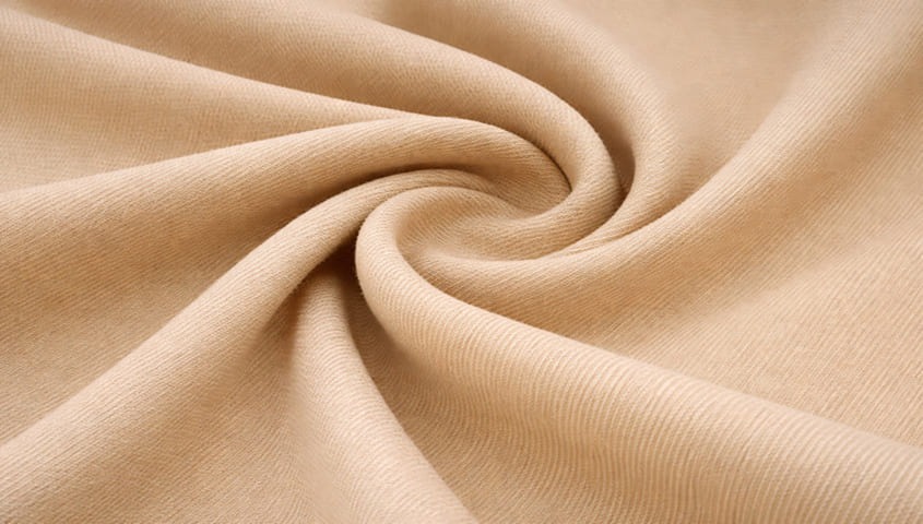 Twill fabric with diagonal weave texture, one of the common types of fabric used in clothing and workwear.