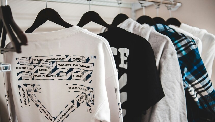 Hanging custom sweatshirts demonstrating what is sublimation printing for detailed, all-over garment designs.