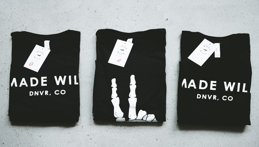 Folded branded t-shirts with tags, showing apparel products sold after building a website with Wix for online stores.