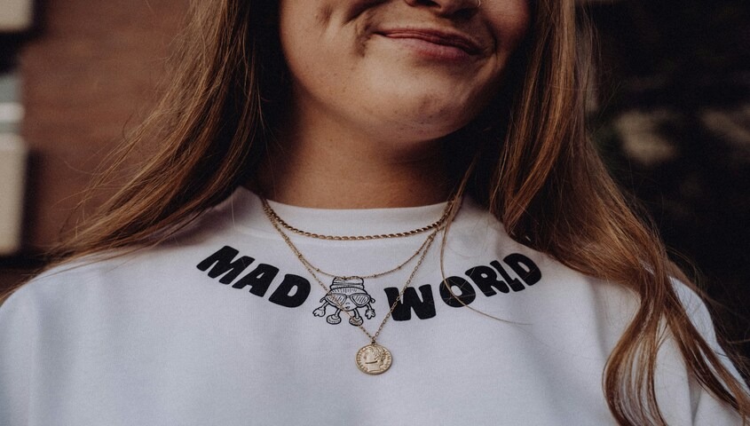 A close-up of a high-quality graphic placement on a white crewneck, showcasing professional tshirt design and the "golden ratio" of print positioning.