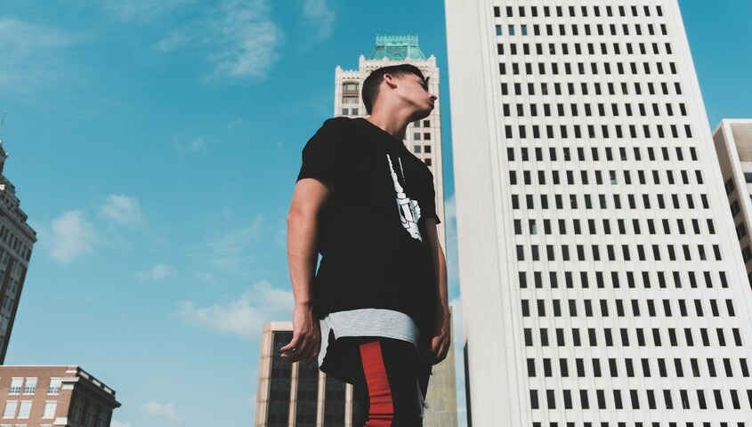 A creator wearing a custom streetwear piece, demonstrating how to design t-shirts that fit into a modern urban lifestyle and brand aesthetic.