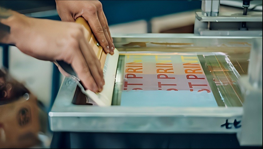 A man doing screen printing on a shirt