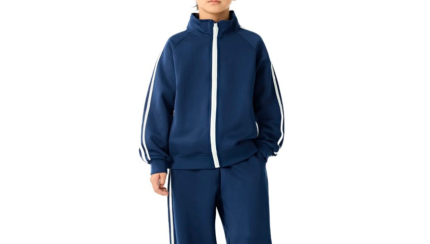Blue track jacket and jogger set reflecting sporty iconic 90s outfits and streetwear fashion.
