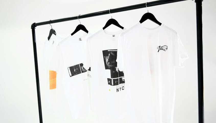 White print on demand shirts hanging on a clothing rack