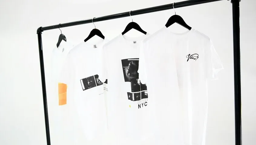 White print on demand shirts hanging on a clothing rack