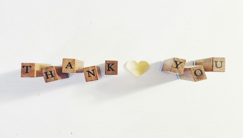 Wooden letter tiles spelling out "thanks for supporting my small business" with a heart between the words.