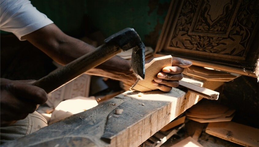 Craftsperson carving detailed woodwork by hand, representing the handmade goods and Etsy seller market for skilled makers
