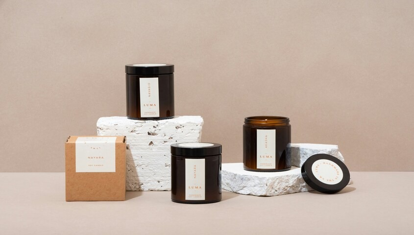 Handmade soy candles displayed on stone, a small-batch product business and one of the most profitable ways to make money as a stay at home mom
