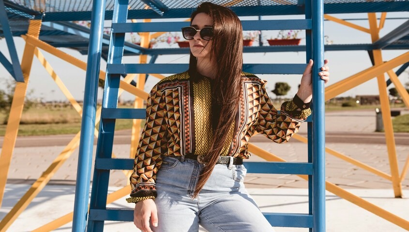 Geometric print 70s blouse paired with modern denim, an example of how to dress 70s with normal clothes