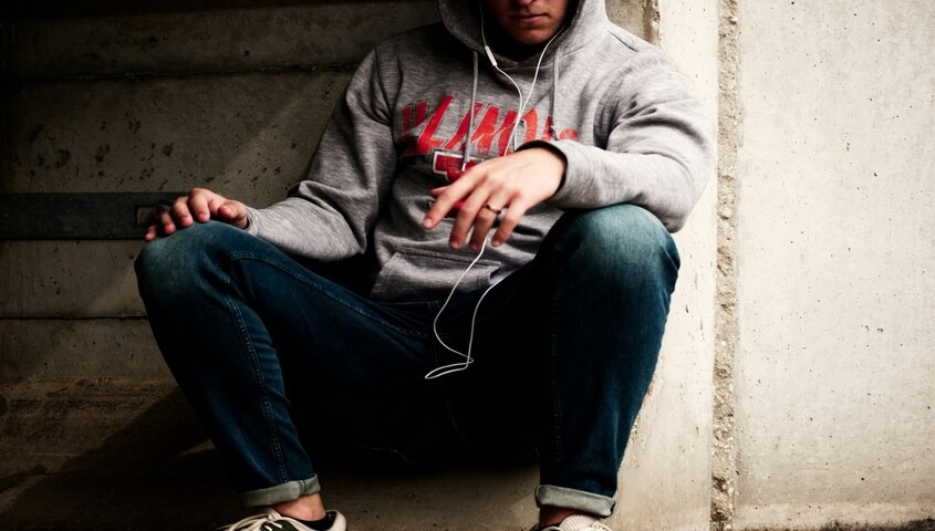 Person wearing a grey graphic hoodie and jeans, a print-on-demand apparel example
