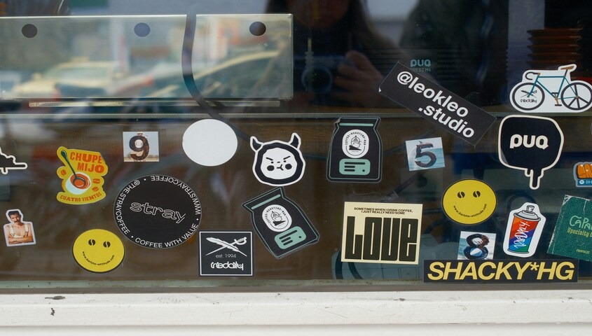 Shop window covered in stickers, a low-cost way to make money as a teen.