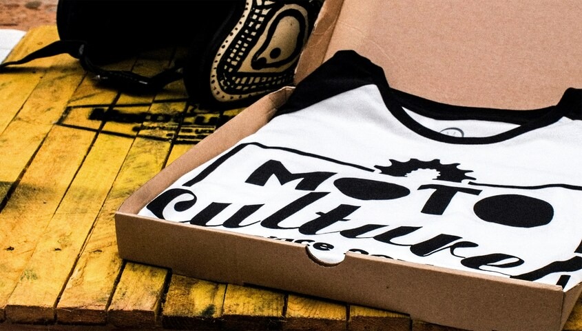 Custom printed t-shirt in a shipping box, a print on demand small business idea for teens.