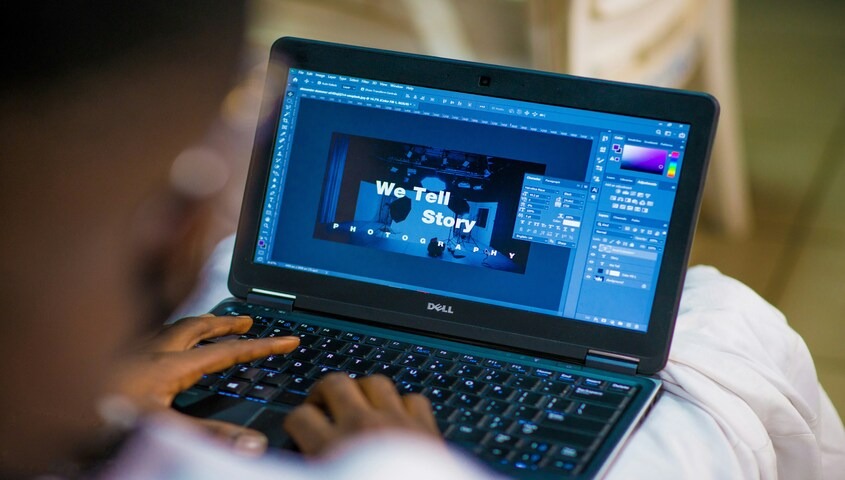 Person editing a design on a laptop, one of the best business ideas for teens with creative skills.