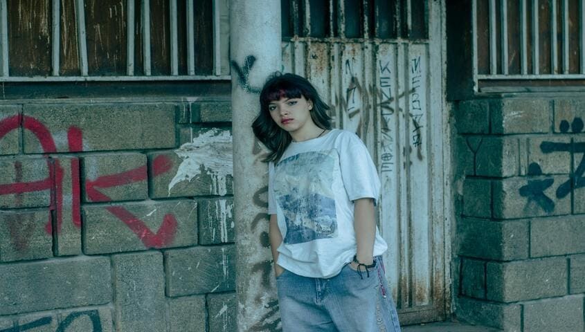 girl shows the oversized front logo placement on shirt