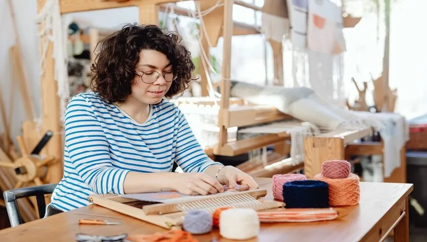 Etsy maker weaving handmade products, illustrating how much does Etsy charge to sell across categories