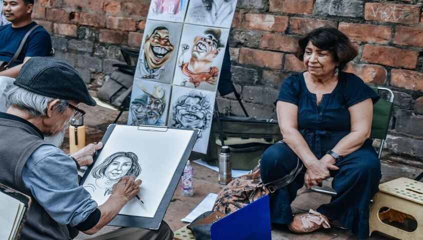 Portrait artist working a commission on the street, a classic answer to how do you make money as an artist.