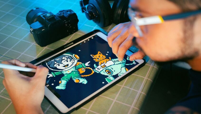 Artist recording a digital illustration tutorial with camera and tablet, one of the most scalable creative ways to make money teaching art online.