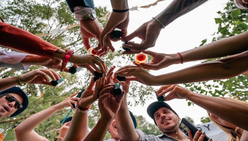 Family members raising drinks together outdoors, showing why family reunion shirts turn a chaotic gathering into a single group identity.