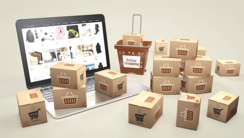 Laptop displaying an online store surrounded by cardboard shopping and delivery boxes.