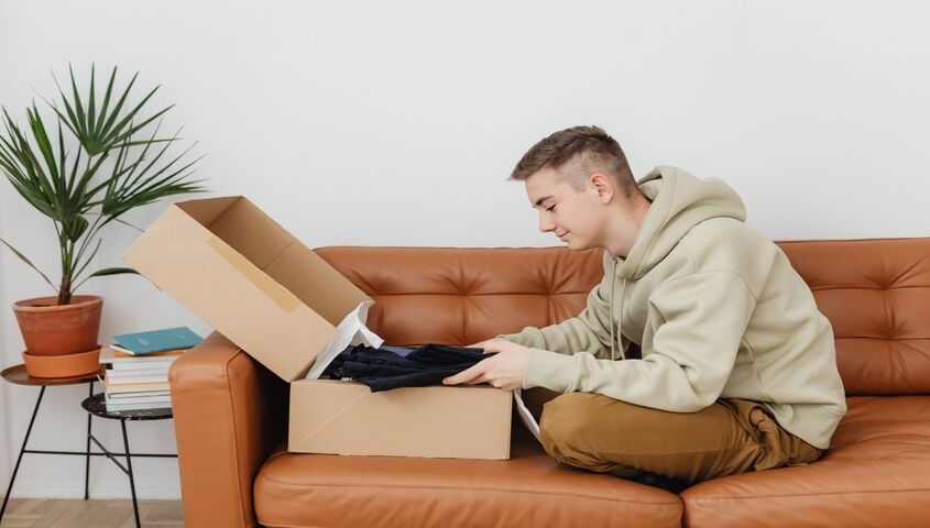 Founder unboxing a sample order at home, showing why catalog depth matters when comparing dropshipping websites for a real brand.