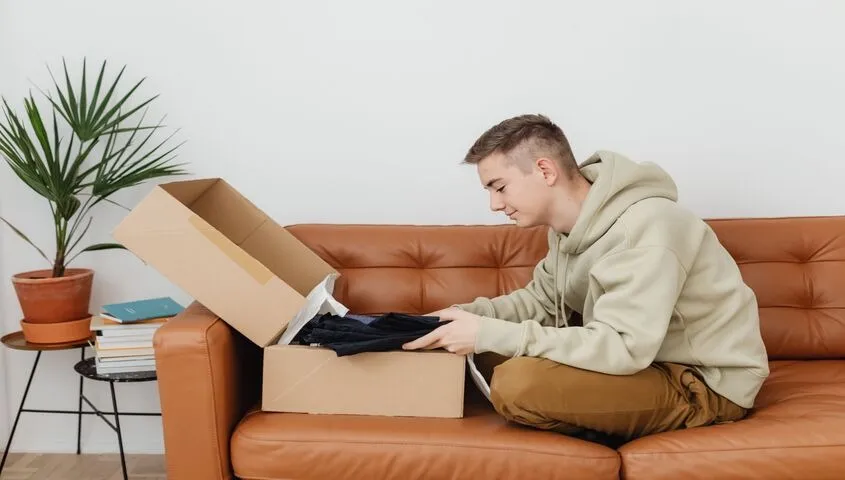 Founder unboxing a sample order at home, showing why catalog depth matters when comparing dropshipping websites for a real brand.