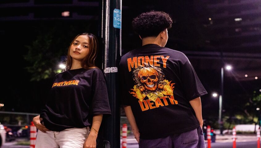 Two models in printed streetwear tees under city lights, showing print on demand as the best business to start with no money in apparel.