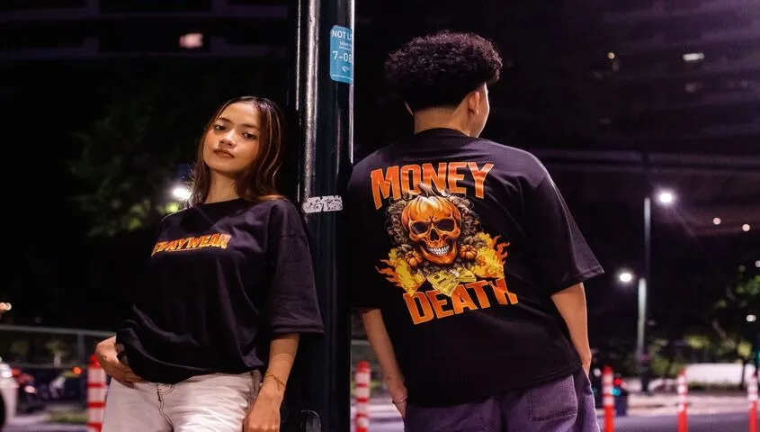 Two models in printed streetwear tees under city lights, showing print on demand as the best business to start with no money in apparel.